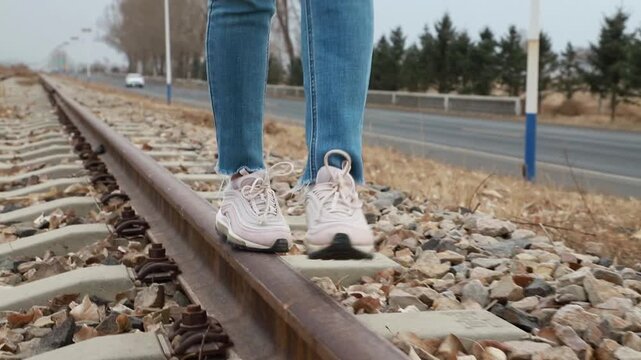 Close up of female feet walking on old railroad ties