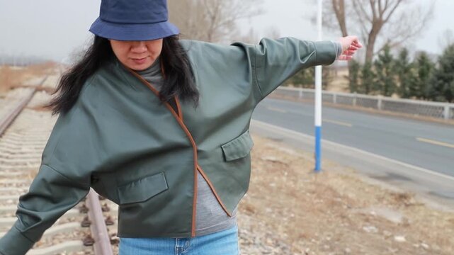 Young woman walking alone on abandoned railway tracks