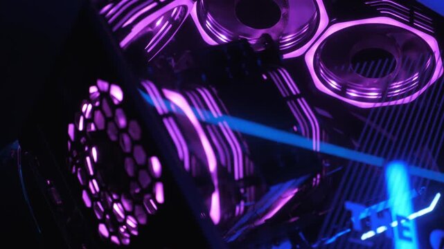 Gaming PC glowing in the dark - the system unit of a modern gaming computer, working of the computer cooling fan with purple light, fans spinning inside the computer, a modern computer gaming club