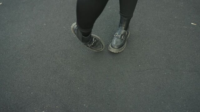 Closeup feet dancing on asphalt, street dancer practicing rhythmic steps in worn sneakers urban pavement texture, solitary rehearsal and fluid footwork conveying casual energy and tempo for lifestyle