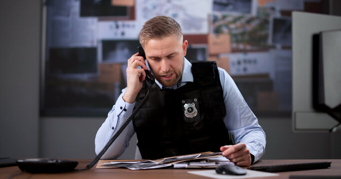 Detective Intently Analyzes Clues During An Important Phone
