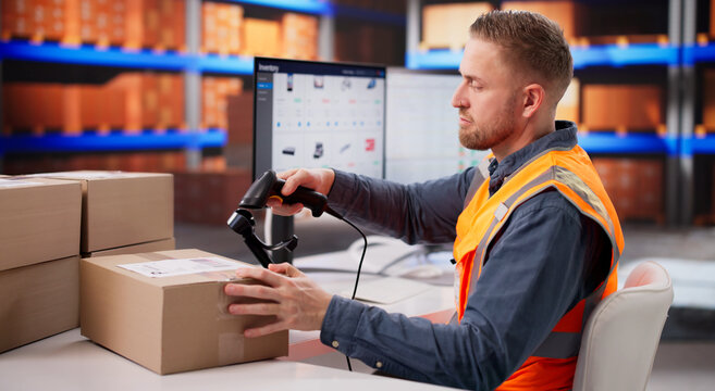 Warehouse Employee Checking Barcode Tags On Boxes
