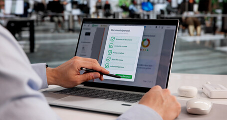 Young Hispanic Male Reviewing And Approving Documents