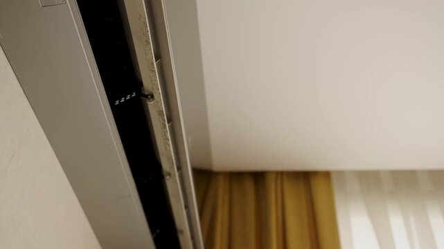 Close-up of Dirty Air Conditioner Vent with Mold and Dust. Split system air conditioner interior showing dust and mold accumulation on the fan blades and vent. Home maintenance and indoor air quality