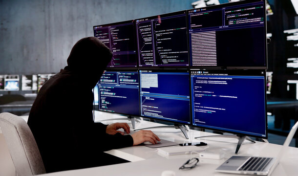 Young Hispanic Programmer Wearing Hoodie Rapidly Typing On Computer