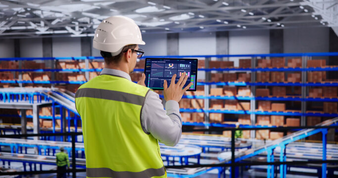 Warehouse Supervisor Reviews Inventory Metrics On Digital Tablet