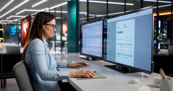 Billing Expert Analyzes Invoices On Desktop Monitor