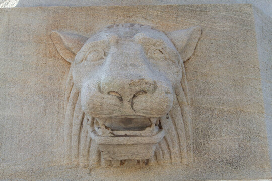 lions head cast of concrete as part of an urban piece of infrastructure such as a city roadway bridge