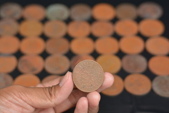 Evaluating an Antique Coin Against a Dark Grid Background