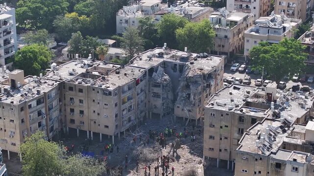 Aerial view Holon Iranian missile strike destruction Israel

Drone footage showing rescue teams at missile impact site in Holon residential area Israel June 14 2025
