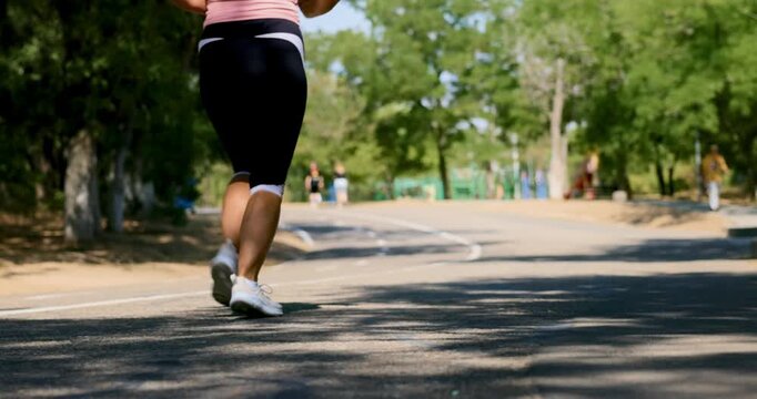 Woman Jogging on a Sunny Outdoor Path in a Park