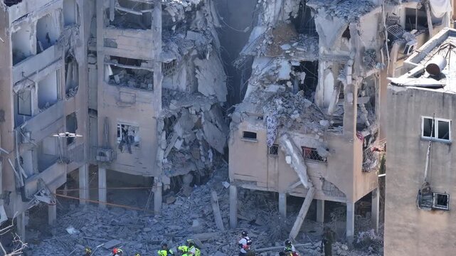Aerial view Holon Iranian missile strike destruction Israel

Drone footage showing rescue teams at Iranian missile impact site in Holon Israel June 14 2025

