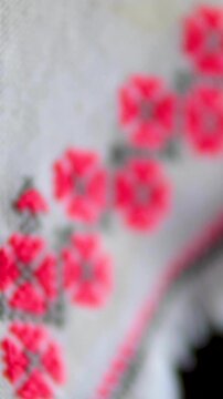 Traditional Ukrainian embroidered white doily with red and black floral cross stitch hanging on cabinet showcasing folk heritage and rustic vintage home decor