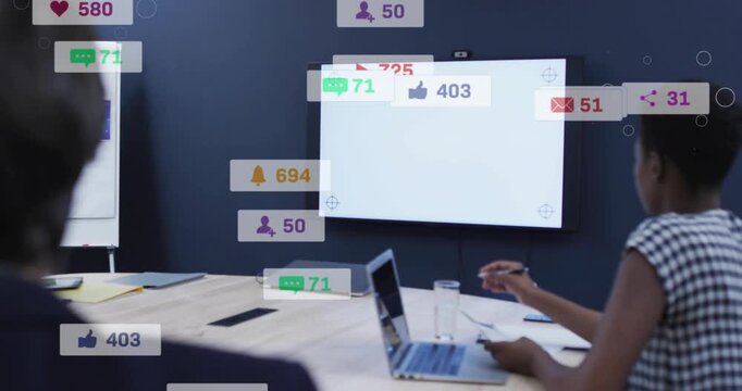 Blank white display appearing, right peer reaching pen as badges piling on table, showing metrics