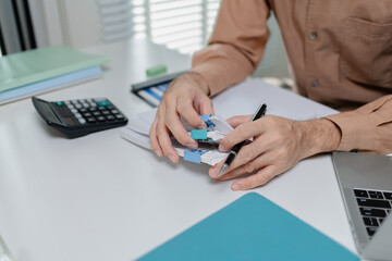 Fototapeta premium Close up of person organizing financial documents with clips on desk, representing paperwork management, accounting process, office organization, and financial record keeping.