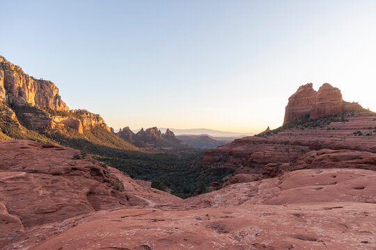 Distant forested valley surrounded by red rock formations