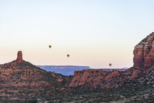 Hot air balloons over red rock formations wide view