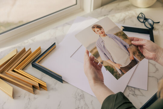 Framing printed portrait of teenager on marble table