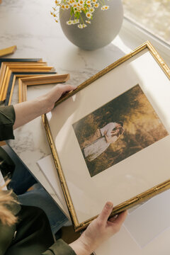 Framed wedding print held by woman indoors