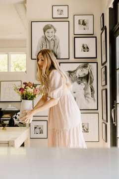 Woman arranging flowers in bright home interior