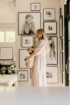Woman holding flowers in modern bright interior