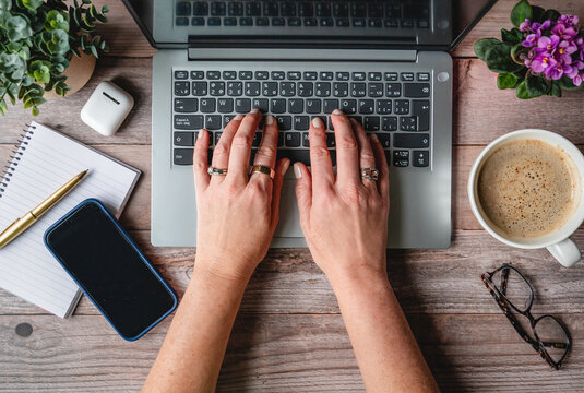 Top view hands typing on computer on desk with phone,coffee.
