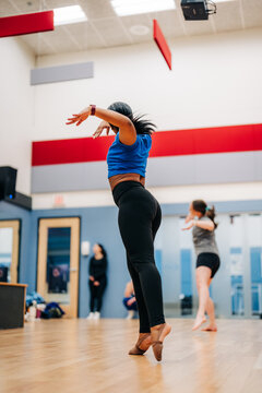 Dancer rehearsing challenging movement in a dance studio