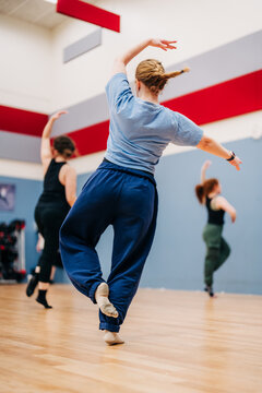 Women dancing in fitness class with flowing arm movements