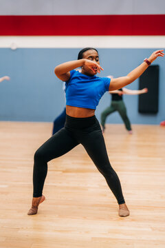 Dancer performing contemporary moves during studio rehearsal session