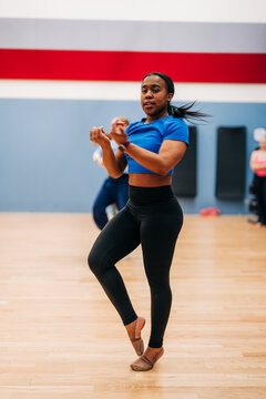 Young black dancer performing steps in studio