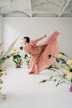 Dancer performing expressive art with graceful movement among flowers