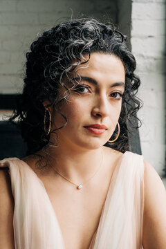 Woman with curly hair wearing elegant gold jewelry