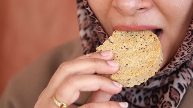 A woman takes a bite of homemade cookies.