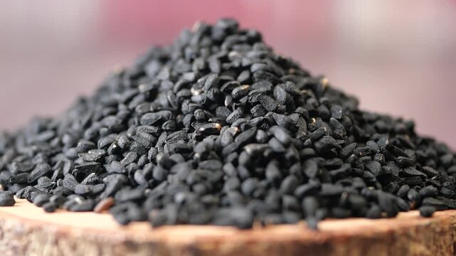 closeup of black cumin seeds on a wooden tray 