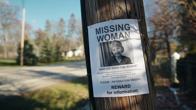 Missing woman flyer attached to wooden pole on quiet suburban street, public appeal for information about disappeared person