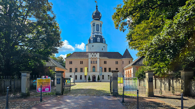 Jever, Lower Saxony, Germany, April 12-2025, Jever castle entrance and historical buildings with green trees under a blue sky
