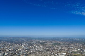 Fototapeta premium High altitude panoramic aerial view of the city of Bradford West Yorkshire UK showing extensive housing industrial areas and green spaces stretching across rolling hills towards the horizon