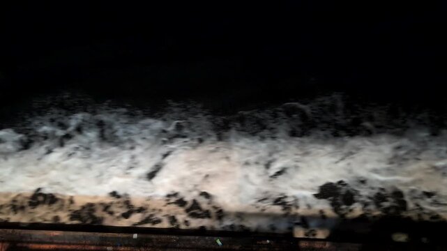 Waves crash on rocky shore at night with sounds of the ocean and natural surroundings