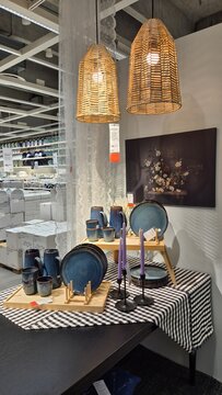Vilnius Lithuania 19.06.2025 ikea showroom dining setup with ceramic tableware candles and wicker pendant lamps creating cozy modern home decor atmosphere in retail interior display