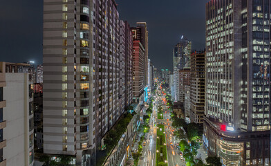 Night view of Le Van Luong Street with illuminated high-rise buildings and busy traffic lines stretching into the distance. © Hanoi Photography