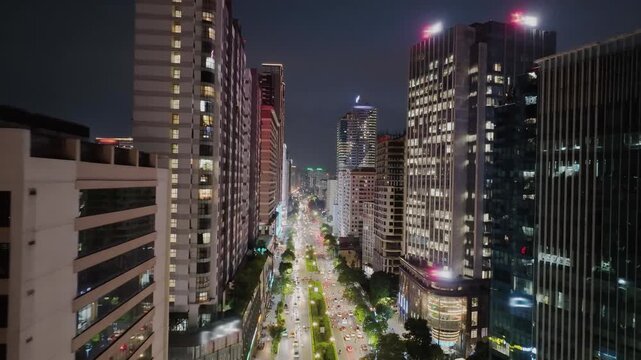 Bright night view of Le Van Luong Street with long lines of traffic and illuminated high-rise buildings.