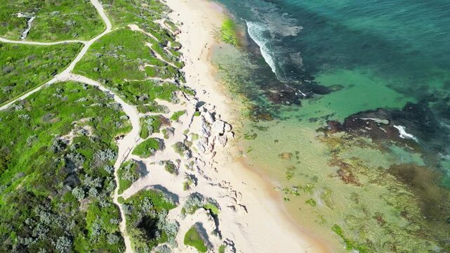 A serene coastal scene featuring soft beach sand merging into rolling sand dunes. The footage highlights the natural textures, gentle curves, and patterns formed by the wind on the dunes. Subtle light