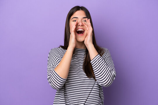Young Brazilian woman isolated on purple background shouting and announcing something