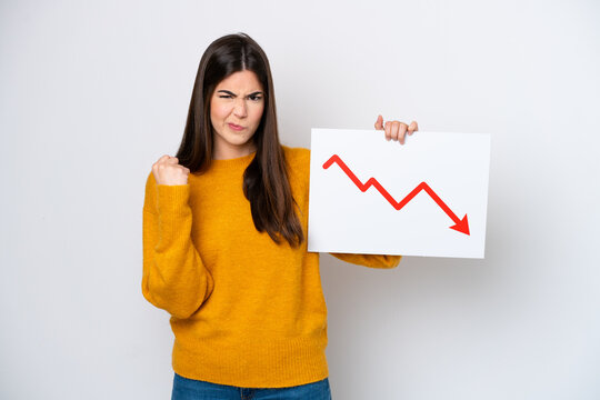 Young Brazilian woman isolated on white background holding a sign with a decreasing statistics arrow symbol and angry