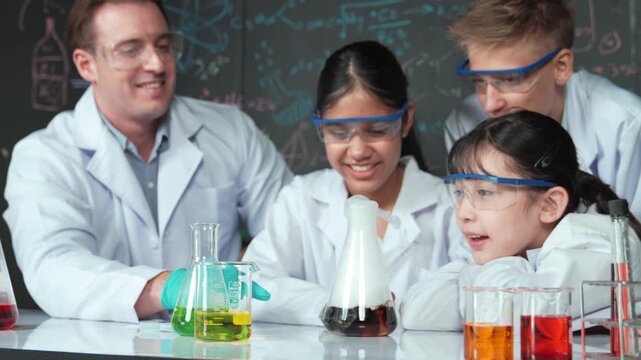 Smart teacher support and look after young diverse children doing experiment together. high school student with mixed races inspect biochemical liquid on table with microscope on table. Edification