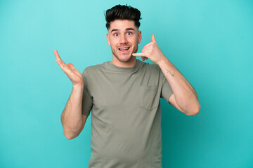 Fototapeta premium Young caucasian man isolated on blue background making phone gesture and doubting