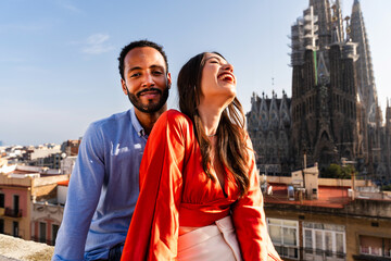 Obraz premium Multiracial beautiful happy couple of lovers dating in Barcelona on a rooftop with amazing city view