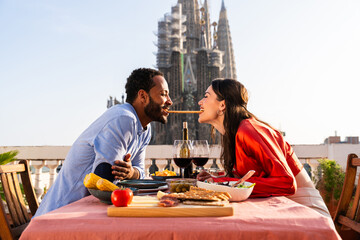 Obraz premium Multiracial beautiful happy couple of lovers dating in Barcelona on a rooftop with amazing city view