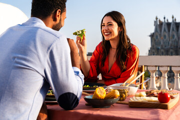 Obraz premium Multiracial beautiful happy couple of lovers dating in Barcelona on a rooftop with amazing city view