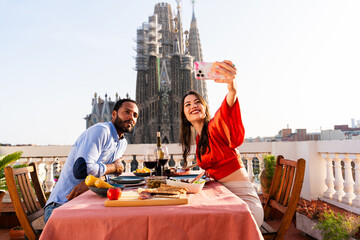 Obraz premium Multiracial beautiful happy couple of lovers dating in Barcelona on a rooftop with amazing city view
